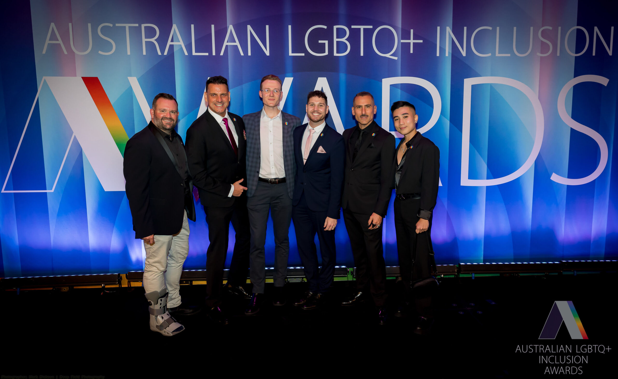 Six men standing on stage at the Australian LGBTQ+ Inclusion Awards